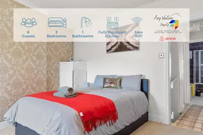 a bedroom with a bed with a red blanket at Workington Haven - 3 Bed Home in Workington