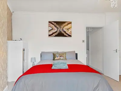 a bedroom with a large bed with a red blanket at Workington Haven - 3 Bed Home in Workington