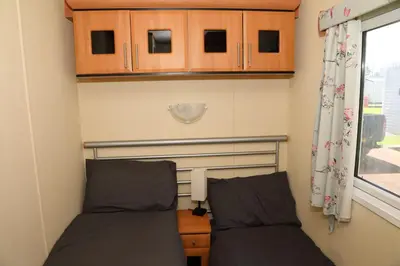 two beds in a small room with a window at Shelly's Stay in Port Carlisle