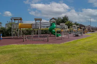 a playground with a green slide in a park at Shelly's Stay in Port Carlisle