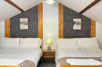 a bedroom with two beds and a table with a lamp at Secluded Hot Tub, Pool, Escape in Bootle