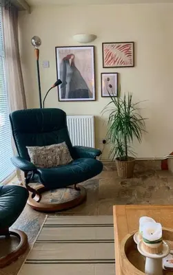 a living room with a blue chair and a table at The Gower Cottages in Moffat
