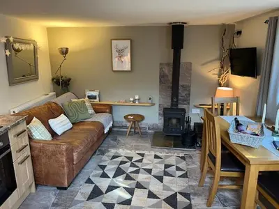 a living room with a couch and a table at The Gower Cottages in Moffat