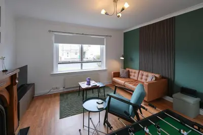 a living room with a couch and a pool table at Barassie Villa located near Troon in Troon