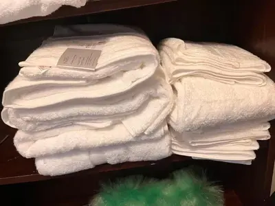 a pile of white towels on a shelf at 5BR House w Garden Near Stadium in Moffat