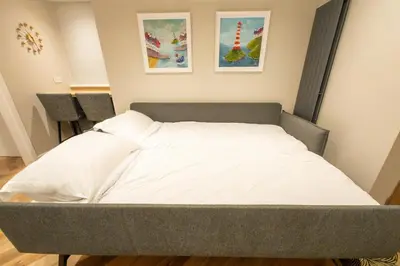 a bed in a room with two pictures on the wall at Stoneyloft Modern Apartment in Glen Vine in Glen Vine
