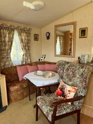 a living room with a couch and a table at Grannys Vintage Coastal Caravan in Kippford