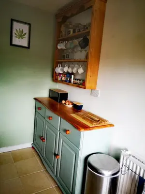 a kitchen with a green cabinet and a counter at Cosy cottage near Thornhill in Closeburn