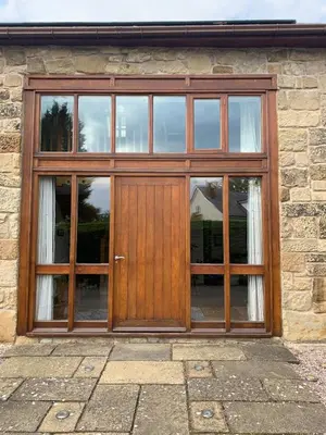 a wooden door on a stone building with windows at Tan Y Bedw Barn in Moffat