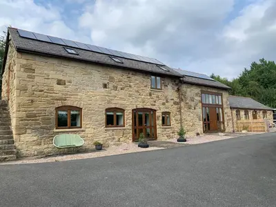 a stone building with solar panels on the roof at Tan Y Bedw Barn in Moffat