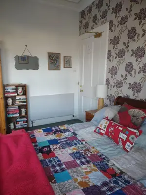 a bedroom with a bed with a quilt on it at 95 St Mary Street in Kirkcudbright