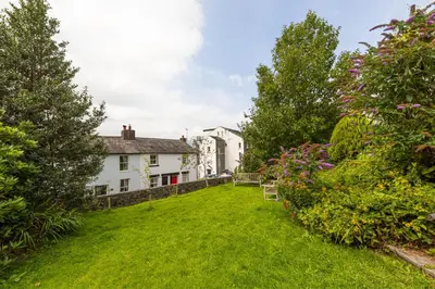 a yard with two white houses and some bushes at Stunning 2 bedroom Apartment in Central Keswick in Keswick
