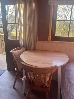 a wooden table and chairs in a room with a window at Mountain View Shepherds Hut in Penrith