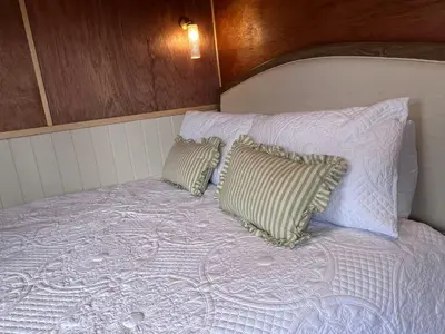 a white bed with two pillows on top of it at Mountain View Shepherds Hut in Penrith