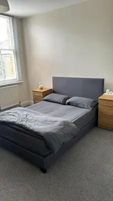 a bedroom with a bed and a window at London Holiday Home - 8mins walk from Station Zone 2 in Moffat