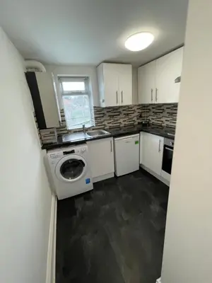 a small kitchen with a washer and dryer in it at London Holiday Home - 8mins walk from Station Zone 2 in Moffat