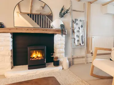 a living room with a fireplace and a mirror at North Lakes - The Byre Holiday Cottage in Penrith