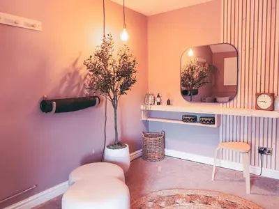 a room with a mirror and a chair and a stool at North Lakes - The Byre Holiday Cottage in Penrith