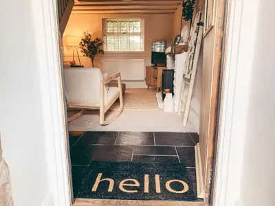 a hallway with a welcome mat on the floor of a room at North Lakes - The Byre Holiday Cottage in Penrith
