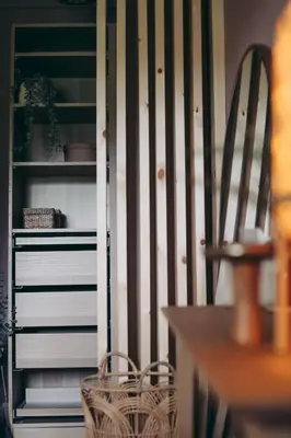 a closet with a book shelf and a wooden chair at North Lakes - The Fold Holiday Cottage in Penrith