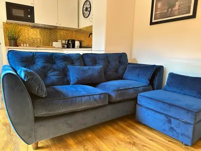 a blue couch sitting in a living room at Scotney Retreat in Moffat