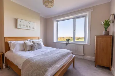 a bedroom with a bed and a window at Spacious 4-Bed Lake District Getaway for Groups in Mealsgate