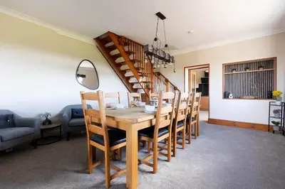 a dining room with a wooden table and chairs at Spacious 4-Bed Lake District Getaway for Groups in Mealsgate