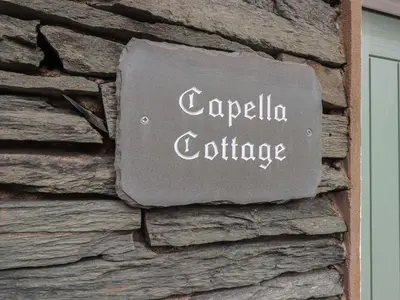 a sign on the side of a stone building at Capella Cottage in Keswick