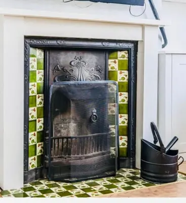 a fireplace in a living room with a tile wall at Lovely spacious home near station in Moffat