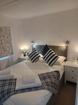 a bedroom with a large white bed with two pillows at Stunning Sea View - Farm Stay - Kilchoman 9 in Stranraer