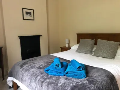 two blue towels sitting on top of a bed at High House Cottage - A traditional home from home in St Bees