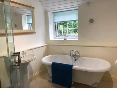 a bathroom with a bath tub and a sink at High House Cottage - A traditional home from home in St Bees