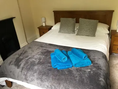 a bed with two blue mitts sitting on it at High House Cottage - A traditional home from home in St Bees