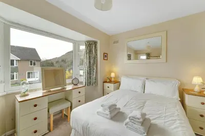 a bedroom with a bed and a desk and a window at Burnmoor in Keswick