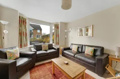a living room with two leather couches and a table at Burnmoor in Keswick