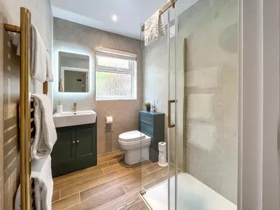 a bathroom with a toilet and a glass shower at Autumn Leaves in Keswick