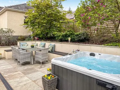 a hot tub in a backyard with a table and chairs at Autumn Leaves in Keswick