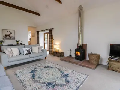 a living room with a couch and a fireplace at The Stables in Thornhill