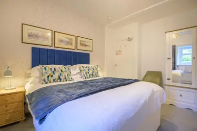 a bedroom with a large bed with a blue headboard at Moss Crag in Penrith