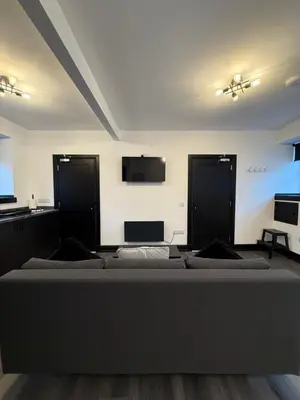 a bedroom with a bed and a tv on the wall at GlasVenn Cottages in Irvine