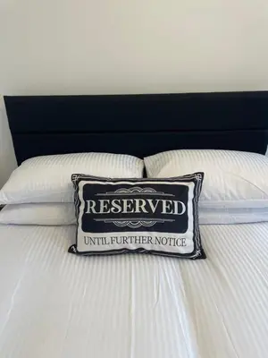 a pillow on a bed with a reserved sign on it at GlasVenn Cottages in Irvine