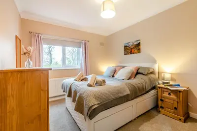 a bedroom with a bed with a dresser and a window at 3 Bed in Aspatria oc-w31951 in Hayton
