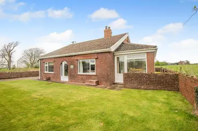 a brick house with a lawn in front of it at 3 Bed in Aspatria oc-w31951 in Hayton