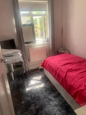 a bedroom with a red bed and a window at Dmoney Ltd in Moffat