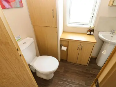 a small bathroom with a toilet and a sink at Cates Cozy Cabin in Carlisle