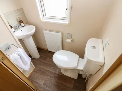a bathroom with a toilet and a sink at Cates Cozy Cabin in Carlisle