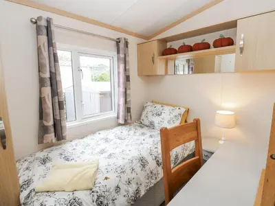 a small bedroom with a bed and a window at Cates Cozy Cabin in Carlisle