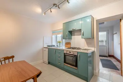 a kitchen with green cabinets and a wooden table at 2 Bed in Allonby oc-i30743 in Allonby