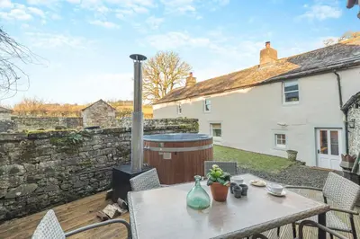 a patio with a table and a brick wall at 3 Bed in Caldbeck oc-h30704 in Caldbeck