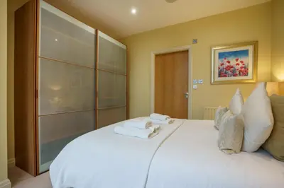 a bedroom with a large white bed with towels on it at Derwent in Keswick